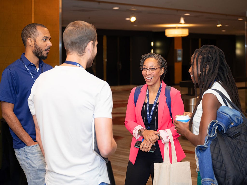 Four XYPN LIVE 2023 attendees smiling and talking. 