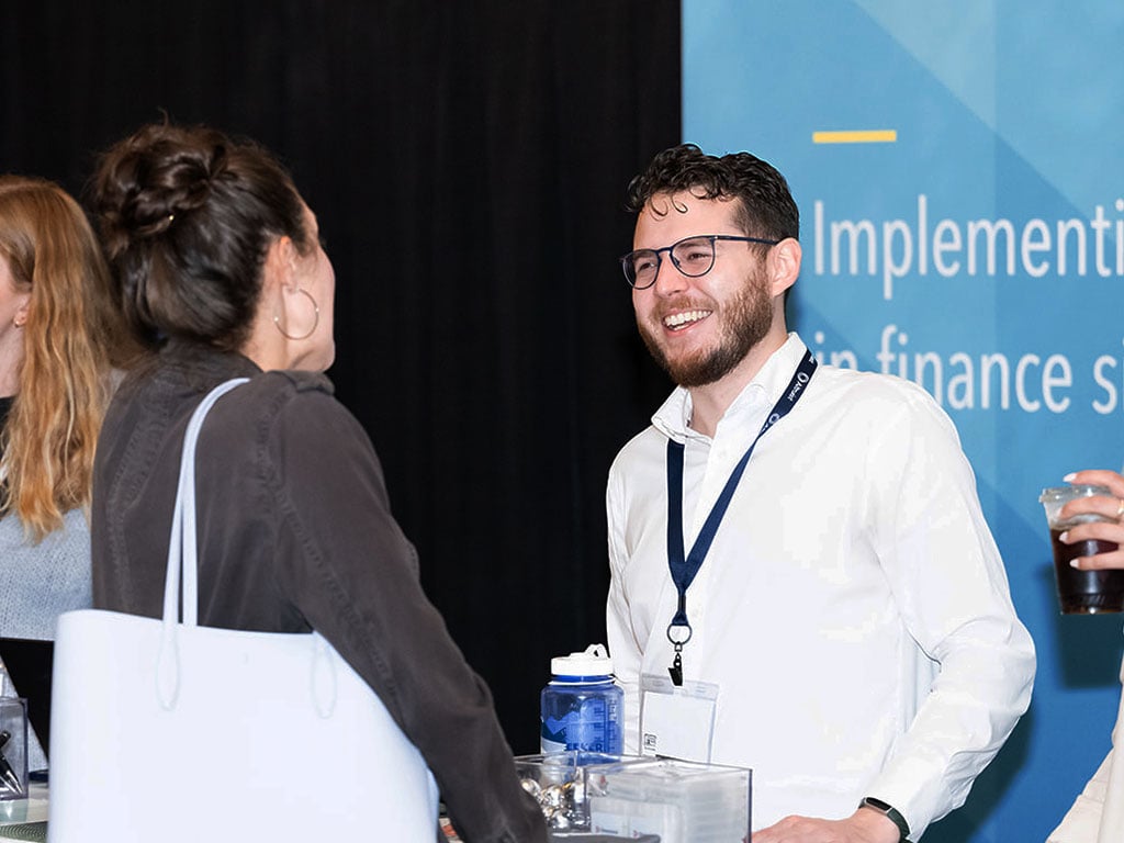 Dimensional Fund Advisors representative smiling while talking with an XYPN LIVE 2023 attendee